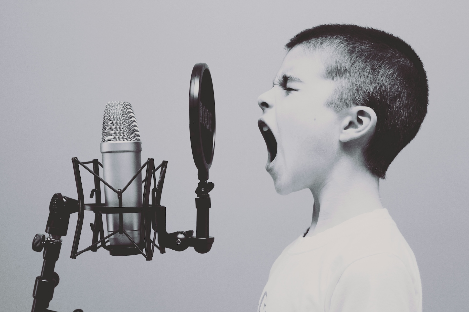 A child singing or shouting into a studio microphone